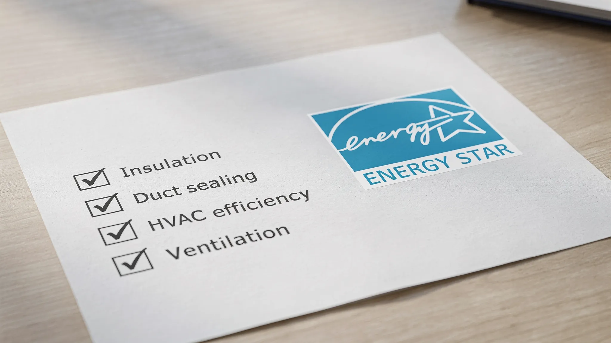 A close-up of an ENERGY STAR label on a home specification sheet next to a simple checklist showing insulation, duct sealing, HVAC efficiency, and ventilation as checked items.