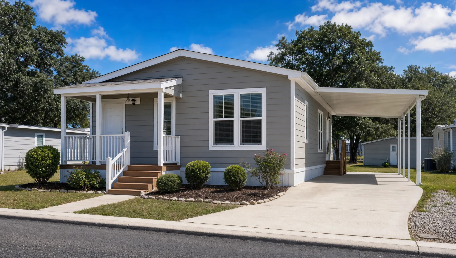 A move-in ready manufactured home in a quiet San Antonio-area community with a small front porch, driveway, neat landscaping, and clear space around the home for inspection.