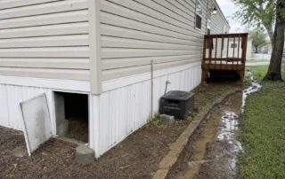 A San Antonio manufactured home site shows skirting, piers, steps, and damp ground where termites can enter.