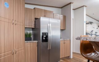 Tall pantry cabinets beside a side-by-side stainless refrigerator