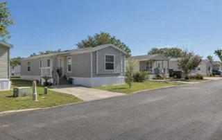 A pre-owned manufactured home sits among established community homes, where buyers can check the site and land arrangement for FHA eligibility.