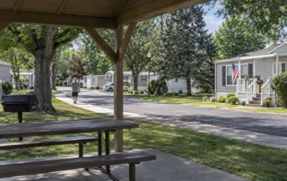 A resident walks a shaded path between homes in an occupied mobile home community being evaluated for purchase.